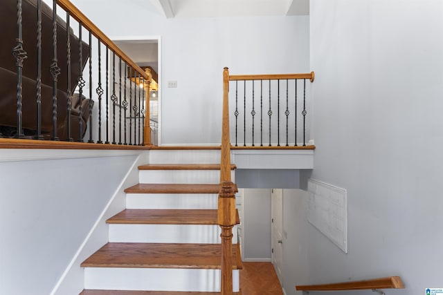 stairway featuring parquet flooring