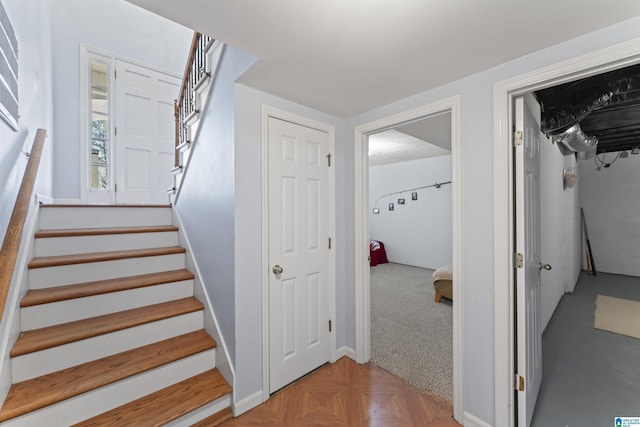 stairway featuring parquet floors