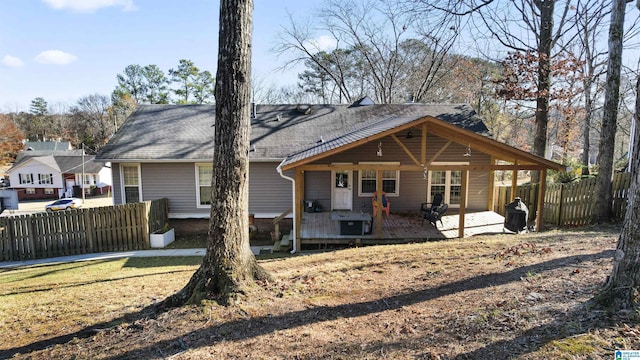 rear view of house with a yard and a wooden deck