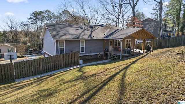 back of house with a deck and a yard