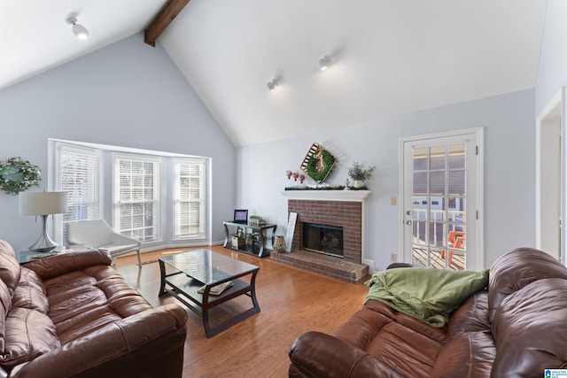 living room featuring a fireplace, light hardwood / wood-style floors, high vaulted ceiling, and beamed ceiling