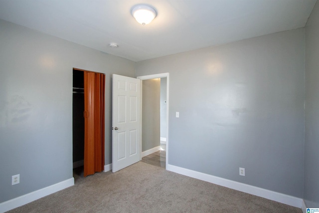 unfurnished bedroom featuring light colored carpet and a closet