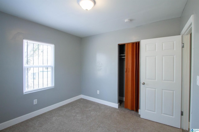 unfurnished bedroom featuring a closet and light colored carpet