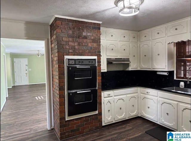 kitchen featuring a textured ceiling, dark hardwood / wood-style floors, white cabinetry, and double oven