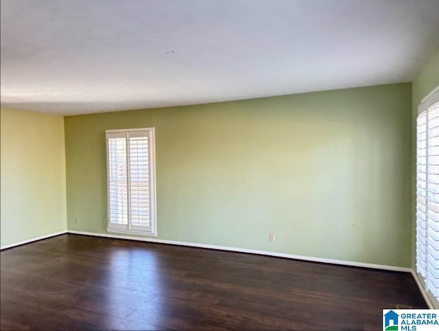 empty room with plenty of natural light and dark wood-type flooring