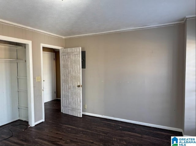 unfurnished bedroom with crown molding, a closet, and dark wood-type flooring