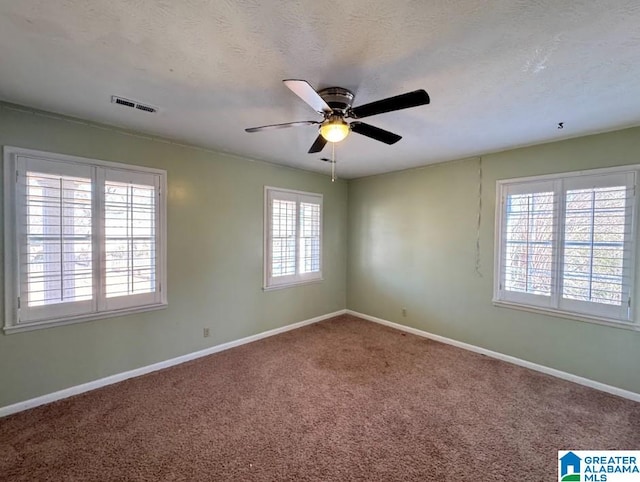 empty room with ceiling fan, carpet, and a healthy amount of sunlight