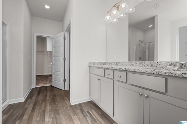 bathroom featuring vanity, hardwood / wood-style flooring, and a shower with shower door