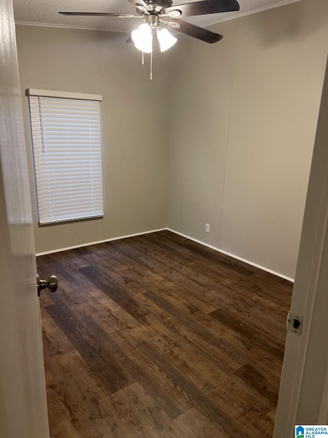 spare room with a textured ceiling, dark hardwood / wood-style floors, ceiling fan, and crown molding