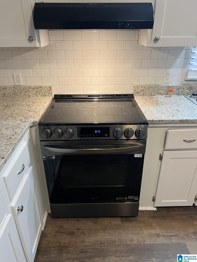 kitchen featuring decorative backsplash, dark hardwood / wood-style flooring, stainless steel range oven, white cabinetry, and range hood