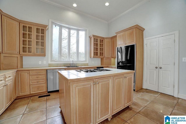 kitchen featuring light brown cabinetry, white gas cooktop, stainless steel dishwasher, and a kitchen island