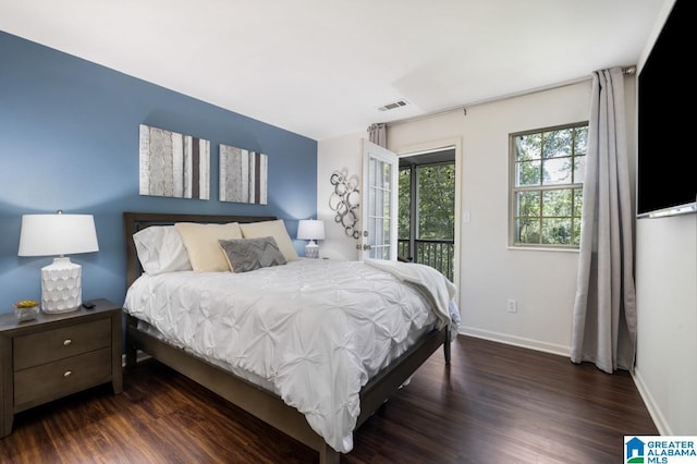 bedroom with dark hardwood / wood-style floors and access to outside