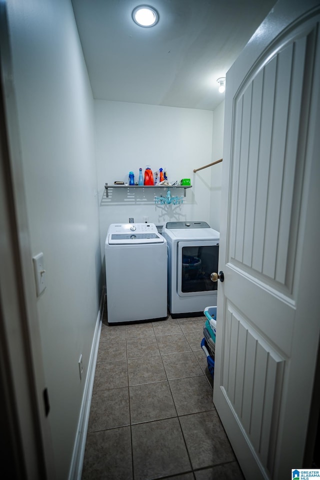 clothes washing area with washer and dryer, baseboards, laundry area, and tile patterned flooring