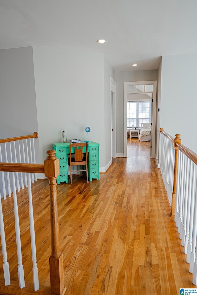 hall featuring recessed lighting, baseboards, an upstairs landing, and light wood finished floors