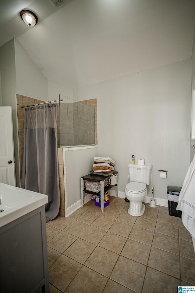 full bath with a shower with shower curtain, baseboards, lofted ceiling, tile patterned floors, and toilet