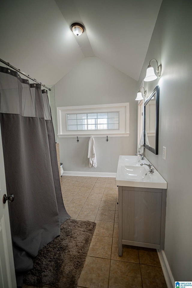 full bath featuring baseboards, lofted ceiling, vanity, and tile patterned flooring