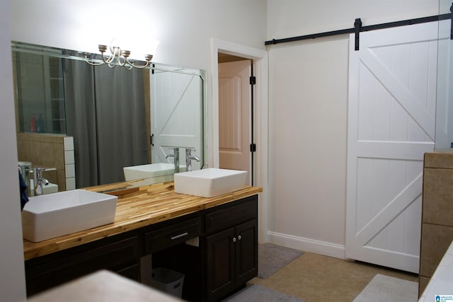 full bath featuring a sink, a chandelier, and double vanity