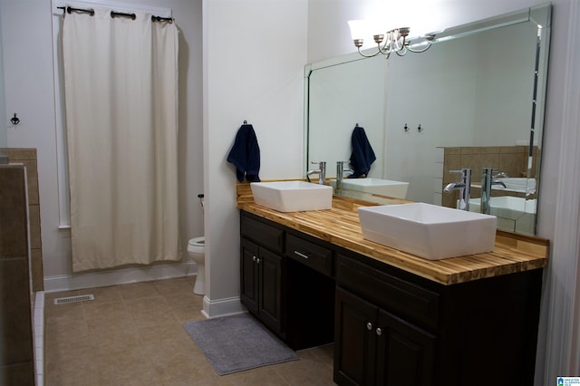 bathroom with an inviting chandelier, visible vents, baseboards, and a sink