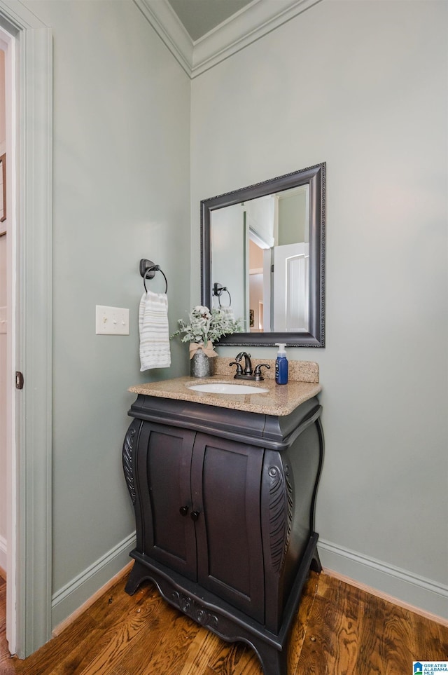 bathroom featuring crown molding, vanity, and wood-type flooring