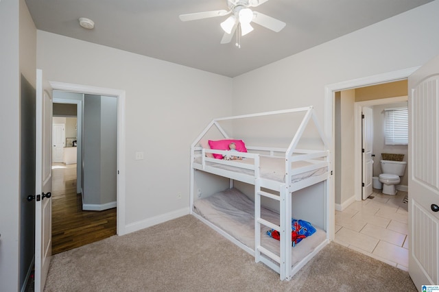 carpeted bedroom featuring ensuite bath and ceiling fan