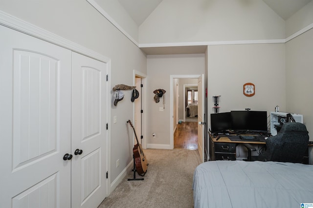 bedroom featuring light carpet, a closet, and lofted ceiling