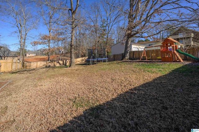 view of yard featuring a playground and a trampoline