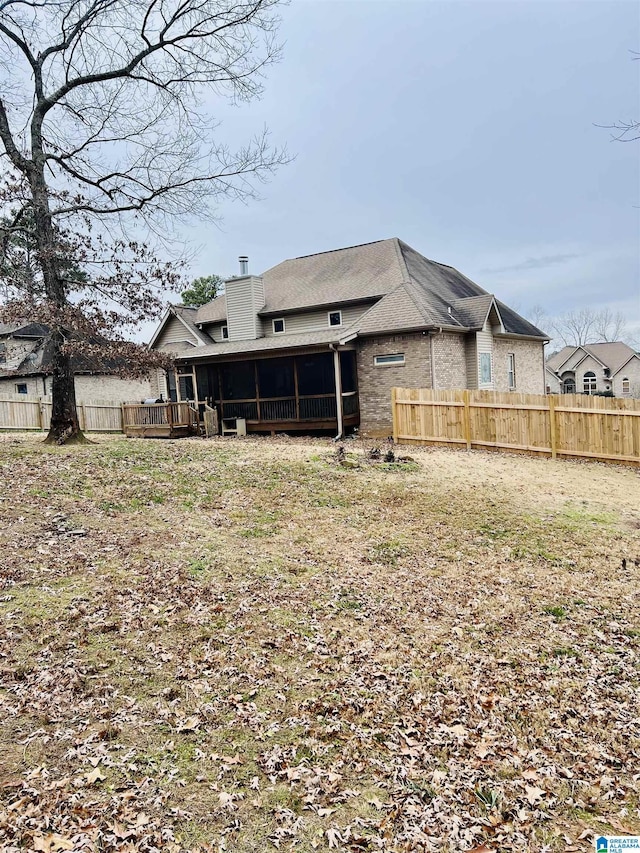 back of property with a sunroom