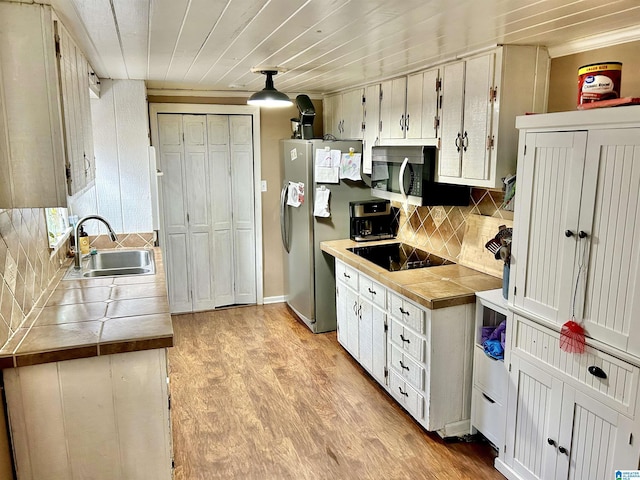 kitchen with sink, white cabinetry, stainless steel appliances, and tasteful backsplash