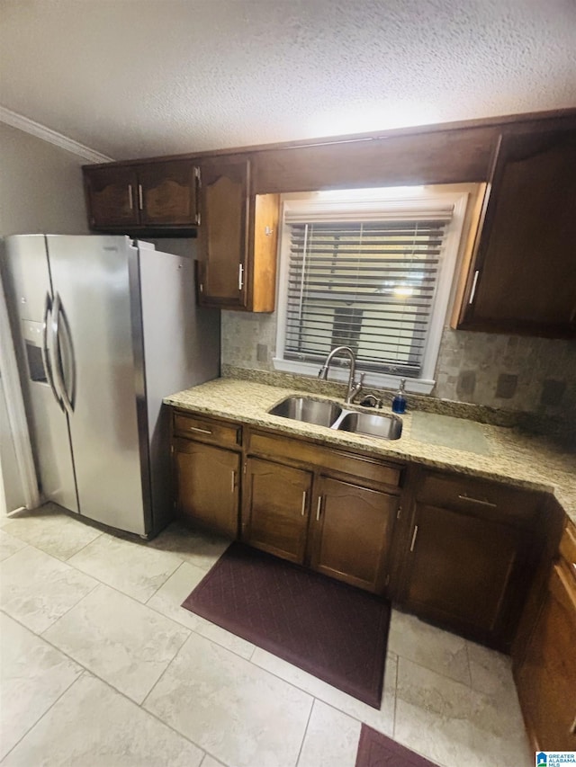 kitchen featuring backsplash, crown molding, sink, a textured ceiling, and stainless steel fridge with ice dispenser