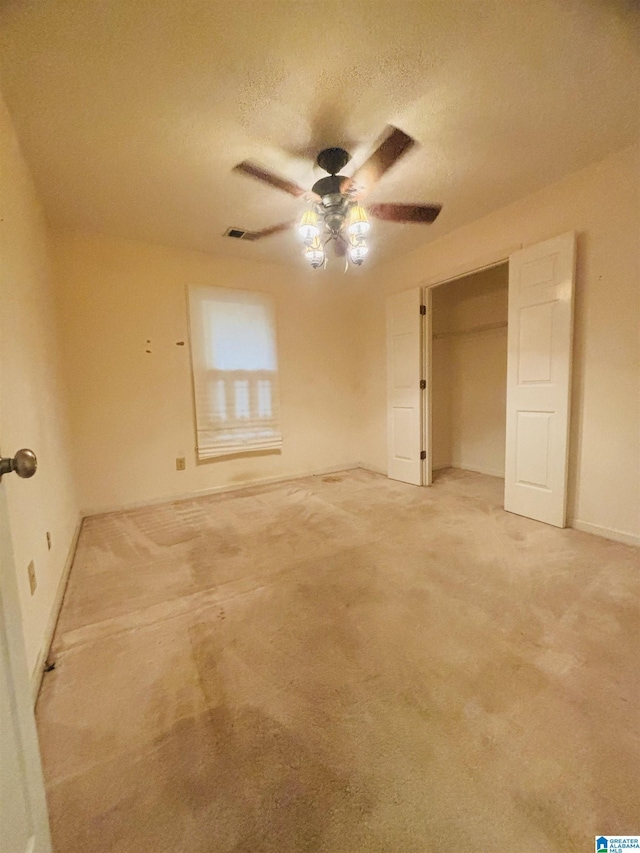 unfurnished bedroom with carpet, a textured ceiling, a closet, and ceiling fan