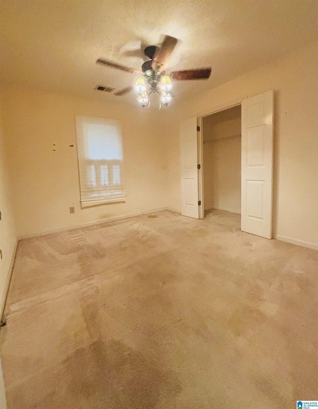 unfurnished bedroom featuring ceiling fan, a closet, carpet floors, and a textured ceiling