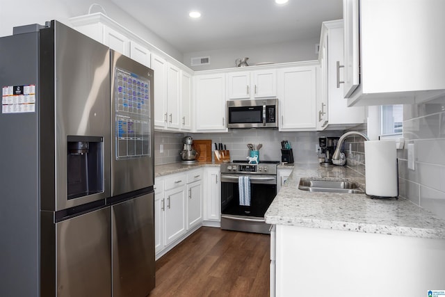 kitchen featuring white cabinetry, sink, dark wood-type flooring, tasteful backsplash, and appliances with stainless steel finishes