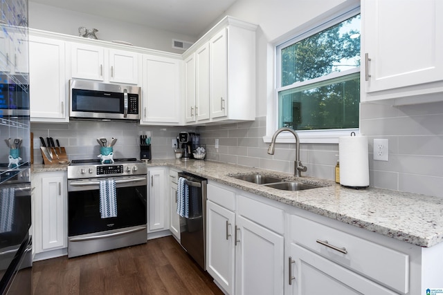 kitchen with decorative backsplash, sink, white cabinets, and appliances with stainless steel finishes