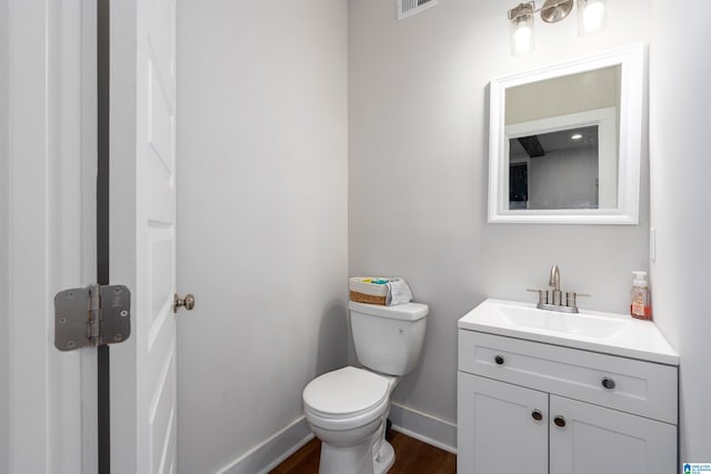 bathroom with hardwood / wood-style flooring, vanity, and toilet