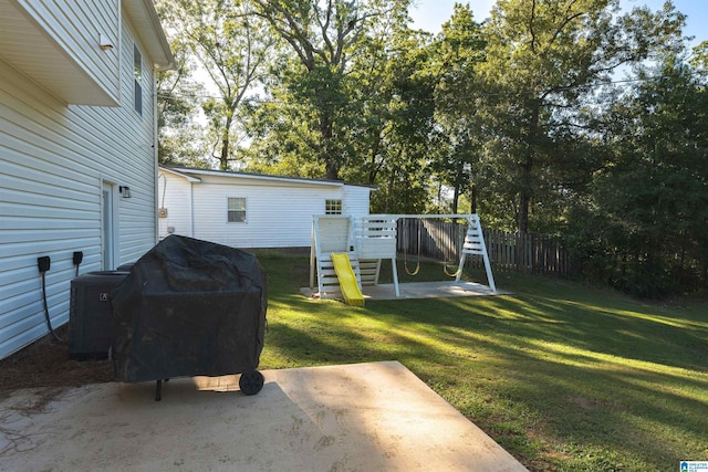 view of yard featuring a playground, central AC, and a patio area