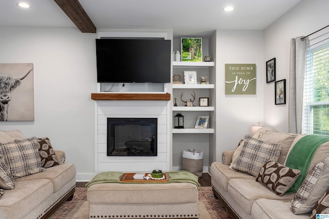 living room with a large fireplace and beam ceiling