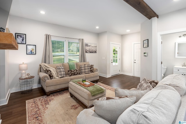 living room featuring beamed ceiling and dark hardwood / wood-style flooring