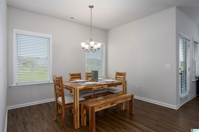 dining room featuring dark wood-type flooring and an inviting chandelier