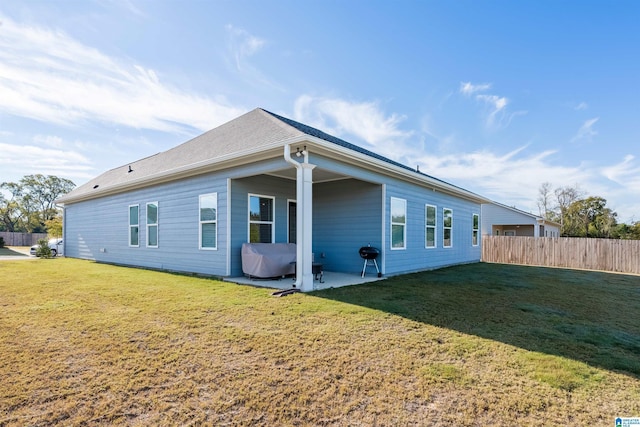 back of property featuring a patio area and a yard