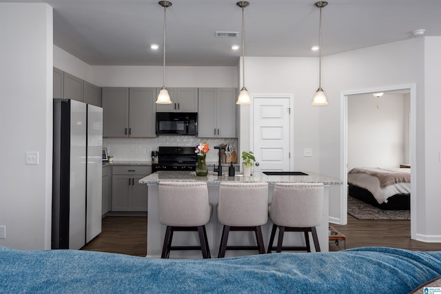 kitchen with tasteful backsplash, gray cabinetry, black appliances, and decorative light fixtures