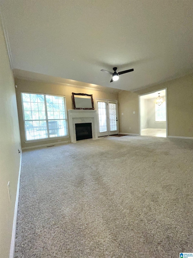 unfurnished living room with carpet floors and ceiling fan with notable chandelier