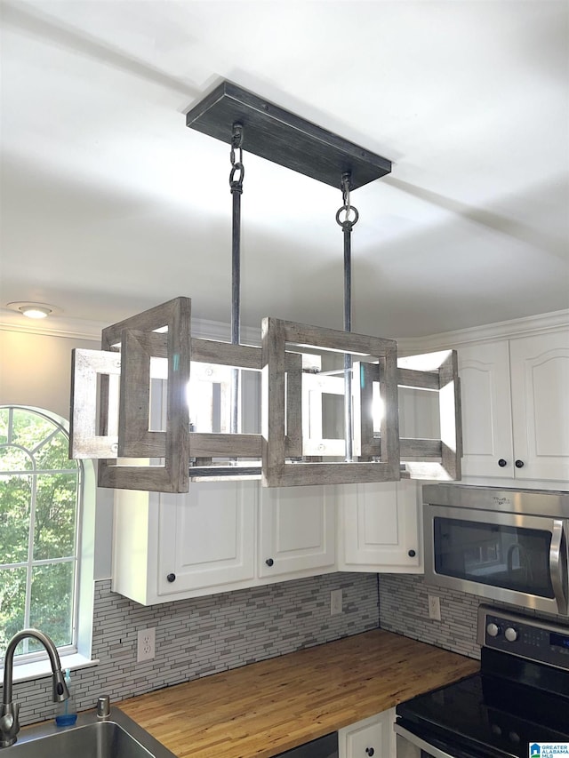 kitchen with white cabinets, decorative backsplash, electric range, and butcher block countertops