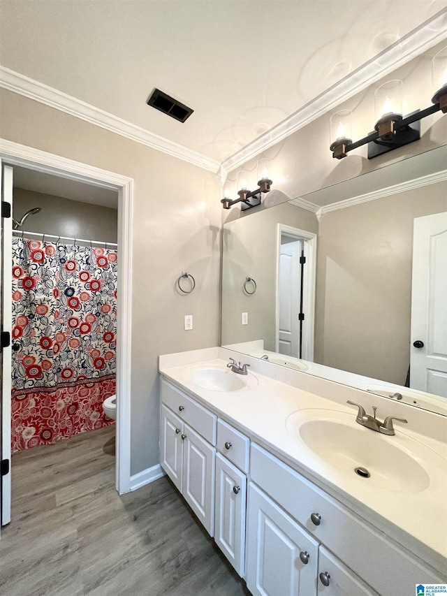 bathroom featuring hardwood / wood-style floors, vanity, crown molding, toilet, and walk in shower