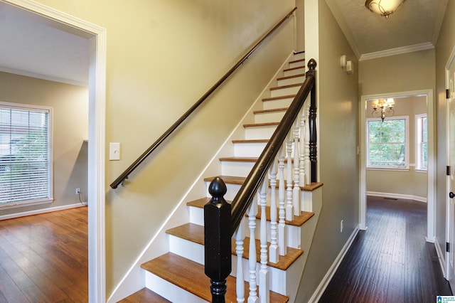 stairs featuring hardwood / wood-style floors, a textured ceiling, crown molding, and a chandelier