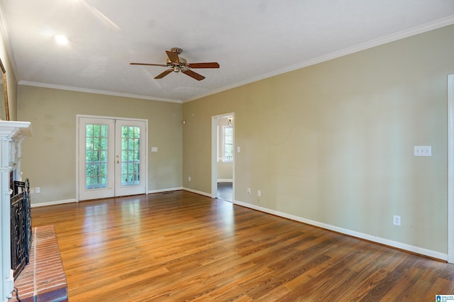 unfurnished living room featuring crown molding, french doors, wood-type flooring, and a brick fireplace