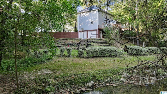 view of yard featuring a water view and a garage