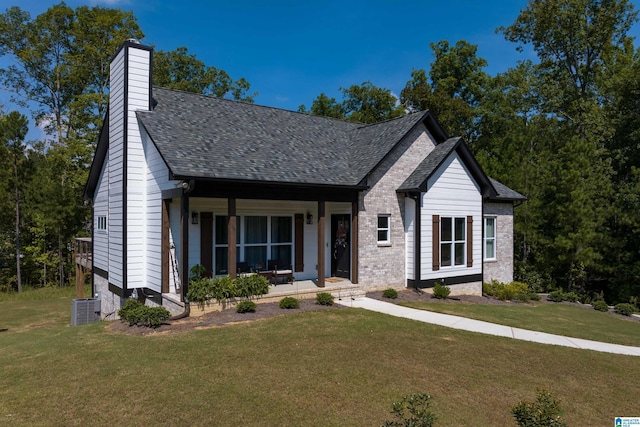 view of front of home featuring a front yard, a porch, and central AC unit