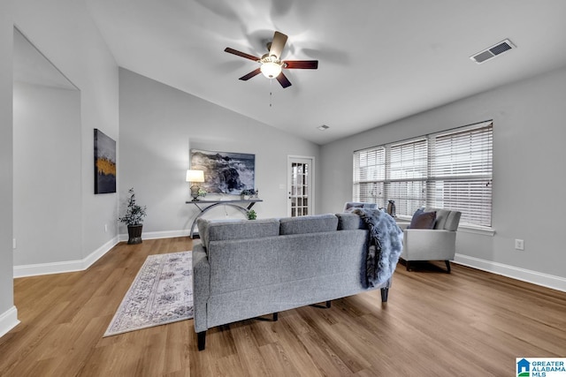 living room featuring ceiling fan, vaulted ceiling, and light wood-type flooring