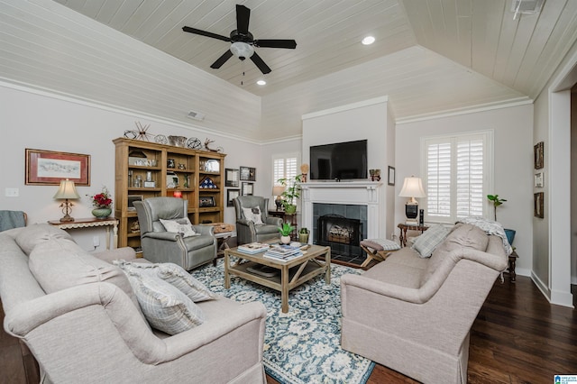 living room with a tray ceiling, ceiling fan, dark wood-type flooring, wooden ceiling, and a tiled fireplace