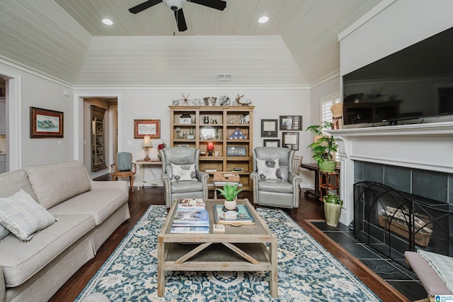 living room with dark hardwood / wood-style flooring, a tiled fireplace, wood ceiling, and vaulted ceiling